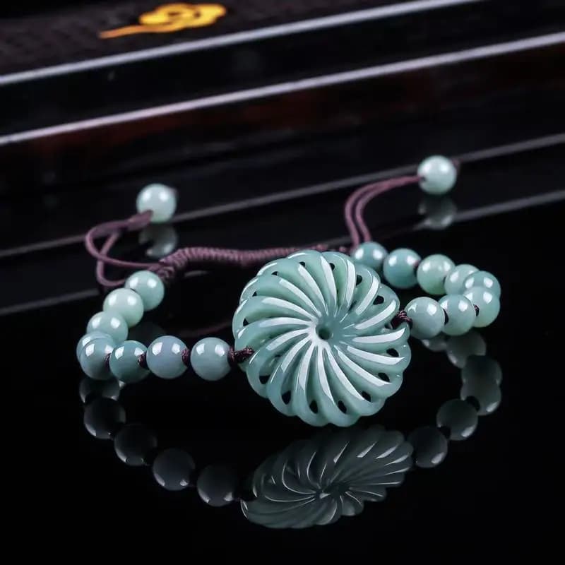 Genuine blue water jadeite bracelet with a carved spiral pendant and round beads.