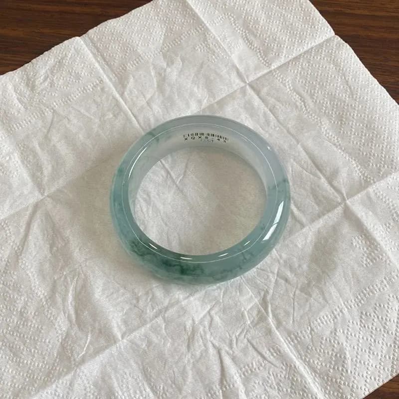 A translucent Ice Burmese Jadeite bangle bracelet with light green hues.