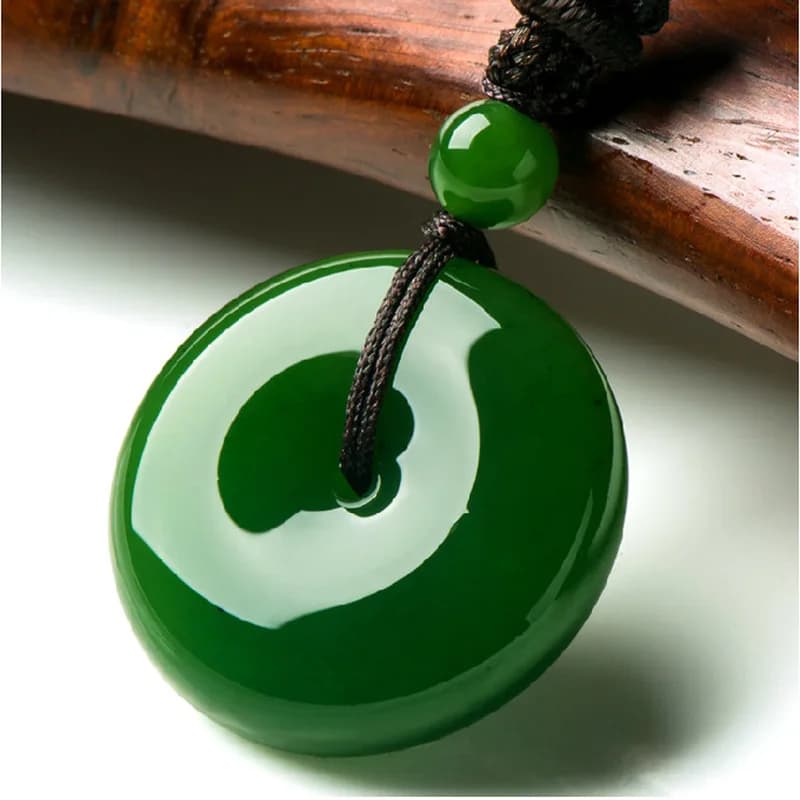 Round green Xinjiang Hotan Jasper peace buckle pendant on a black cord.