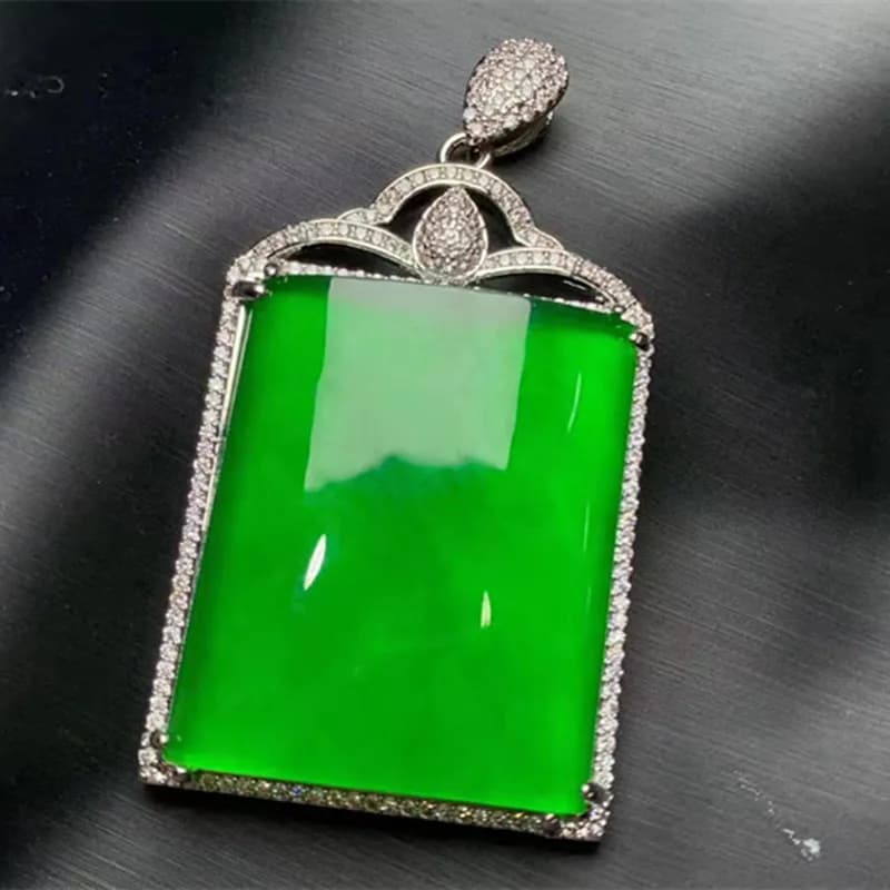 Imperial green ice-clear stone pendant with detailed 18k gold-style inlay frame.