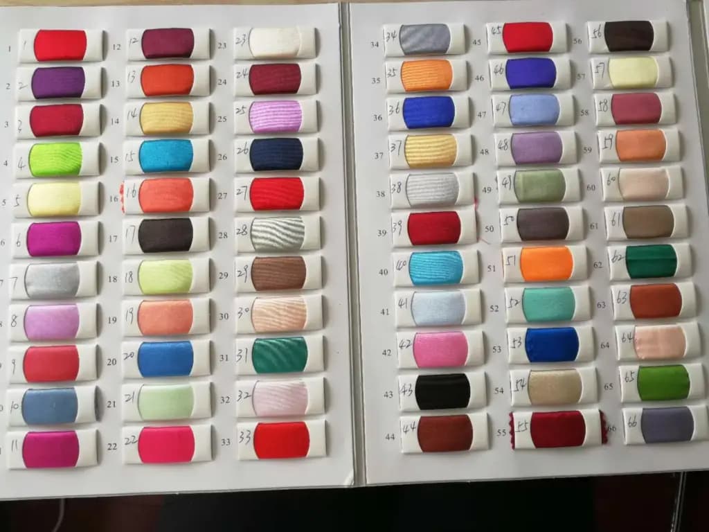 A comprehensive color swatch book displaying dozens of vibrant fabric samples for custom dressmaking.
