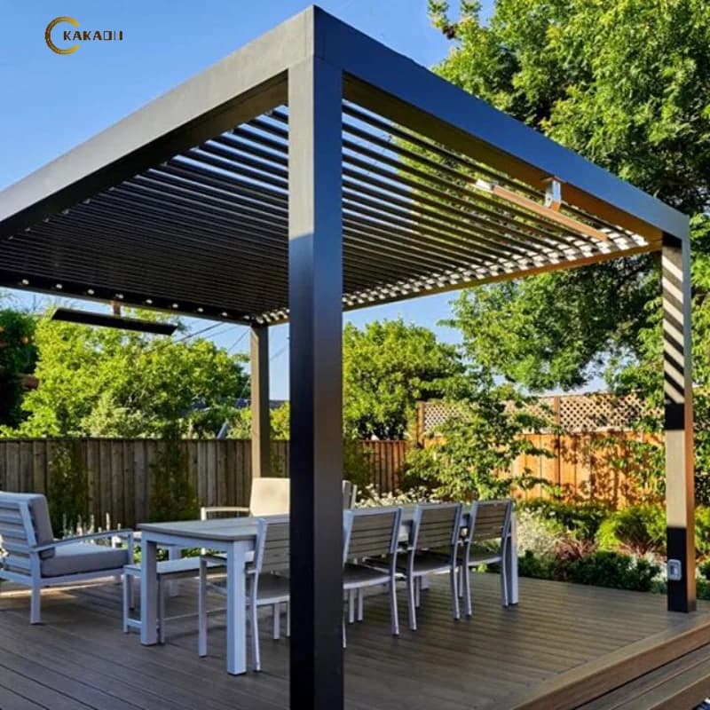 Modern black aluminium electric bioclimatic pergola over an outdoor dining set in a lush garden