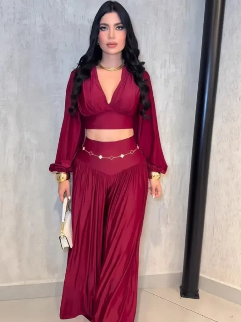 Woman wearing a burgundy two-piece matching set with a crop top and wide-leg flared pants.